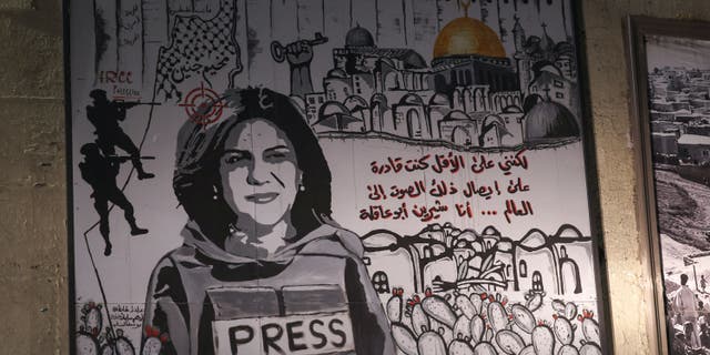 A mural depicting slain Palestinian-American journalist Shireen Abu Akleh is illuminated with headlights on a street in the Arab city of Umm Al-Fahm in northern Israel September 5, 2022. 