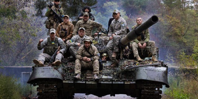 Ukrainian troops ride upon a repaired Russian tank in a wooded area outside the city on Sept. 26, 2022 in Kharkiv, Ukraine. Mechanics are repairing captured Russian tanks that were damaged in battle, so that they can be used by the Ukrainian military against their enemy. 