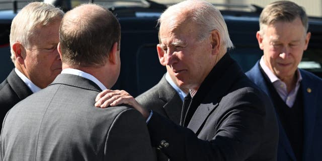 US President Joe Biden speaks to Colorado Governor Jared Polis after disembarking Air Force One at Eagle County Regional Airport in Gypsum, Colorado, on October 12, 2022.