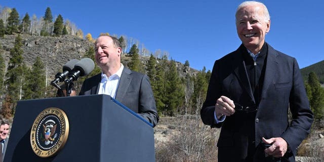 US President Joe Biden (R) smiles as Colorado Governor Jared Polis delivers remarks about protecting America's iconic outdoor spaces at Camp Hale near Leadville, Colorado, on October 12, 2022.