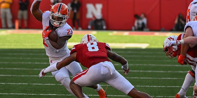 Running back Reggie Love III (23) of the Illinois Fighting Illini attempts to avoid a tackle from defensive back Myles Farmer (8) of the Nebraska Cornhuskers Oct. 29, 2022 in Lincoln, Neb. 