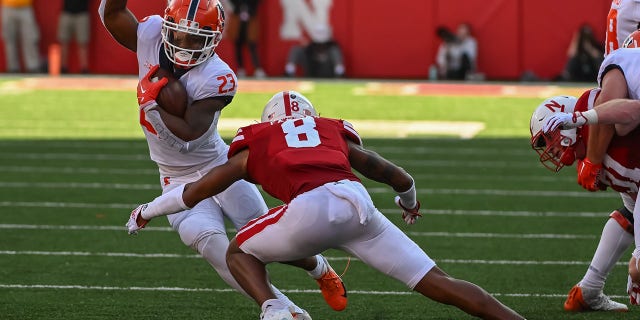 Running back Reggie Love III (23) of the Illinois Fighting Illini attempts to avoid a tackle from defensive back Myles Farmer (8) of the Nebraska Cornhuskers Oct. 29, 2022 in Lincoln, Neb.