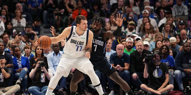 Luka Doncic, #77 of the Dallas Mavericks, handles the ball during the game against the Orlando Magic, Kevon Harris, #7 of the Orlando Magic, plays defense on Oct. 30, 2022 at the American Airlines Center in Dallas.