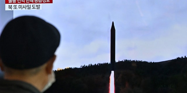 A man looks at a television screen showing news footage of a North Korean missile test, at a train station in Seoul on November 2, 2022. 