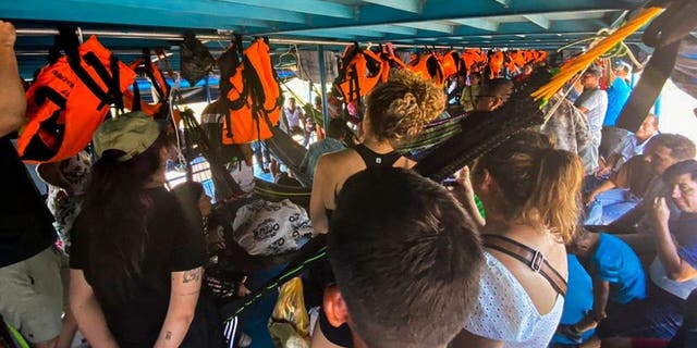 Foreign and Peruvian tourists wait in the boat where they have been detained in Loreto, north of Peru, on Nov. 4, 2022.
