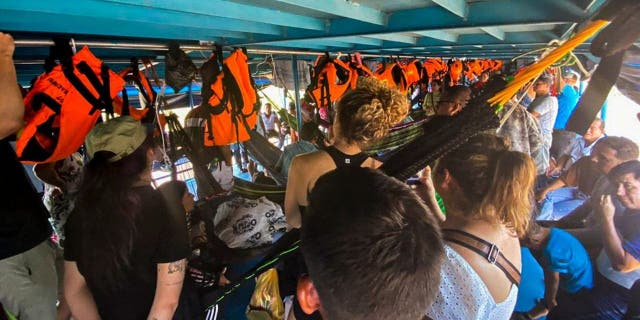 Foreign and Peruvian tourists wait in the boat where they were detained in Loreto, northern Peru, on November 4, 2022.