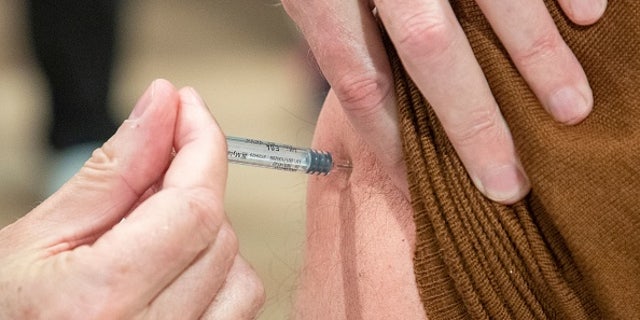 A patient receives a dose of vaccine during a vaccination campaign against the flu.