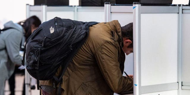 People fill out their ballots at Cathedral High School in Boston on Nov. 8, 2022.