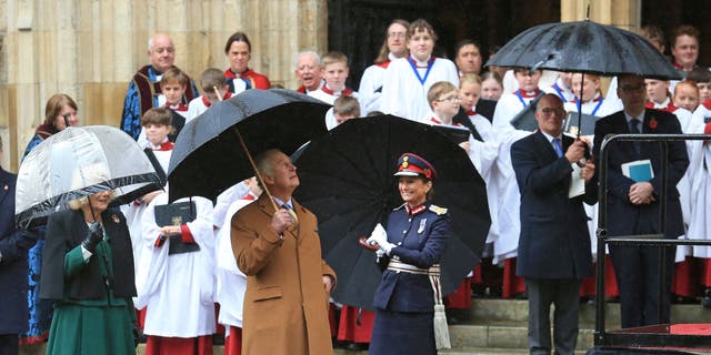 King Charles looks up as a statue of his mother, the late Queen Elizabeth II, is unveiled.