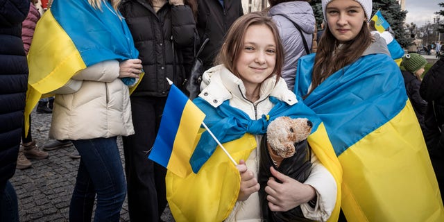 Хората пият пенливо вино, развяват знамена и пеят песни, докато празнуват освобождаването на част от Херсон на Площада на независимостта на 12 ноември 2022 г. в Киев, Украйна. 