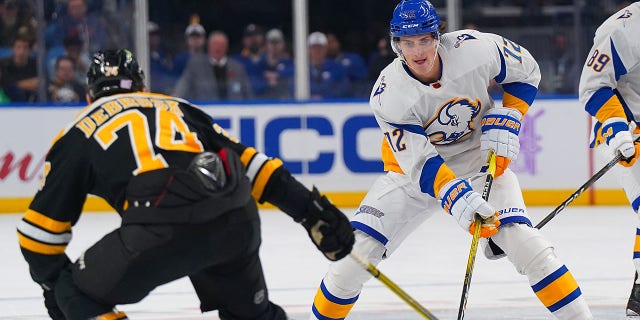 Tage Thompson (72) of the Buffalo Sabres skates up ice with the puck as Jake DeBrusk (74) of the Boston Bruins defends during the second period at KeyBank Center Nov. 12, 2022, in Buffalo. 