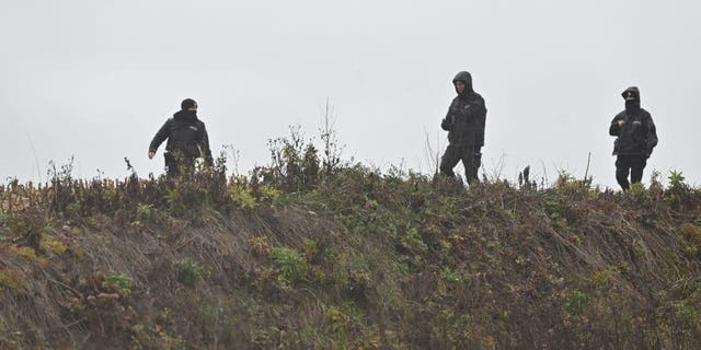 Membri della polizia perquisiscono i campi vicino al villaggio di Przewodow nel Voivodato di Lublino, visti il ​​16 novembre 2022 a Przewodow, in Polonia.