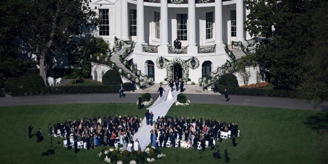 Naomi Biden, 28, granddaughter of President Biden, and Peter Neal, 25, walk to the White House following their wedding on the South Lawn on Nov. 19, 2022.