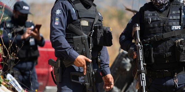 Mexican police standing by at the scene of the gravesite. 