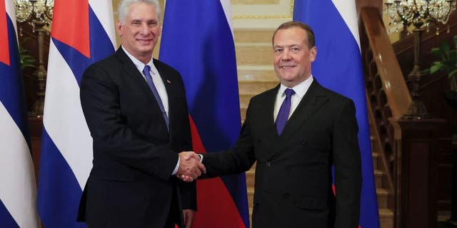 Russia's Security Council deputy head Dmitry Medvedev, right, shakes hands with Cuban President Miguel Diaz-Canel during their meeting at the Gorky state residence outside Moscow on November 21, 2022. (Yekaterina Shtukina/Sputnik/AFP via Getty Images)