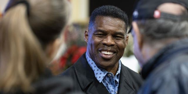 Former GOP Senate nominee Herschel Walker talks with supporters during a rally on Nov. 21 in Milton, Georgia. 