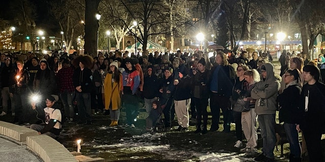 People hold candles during a vigil at Acacia Park for the victims of a mass shooting at Club Q, an LGBTQ nightclub in Colorado Springs, Colorado, on November 21, 2022. 