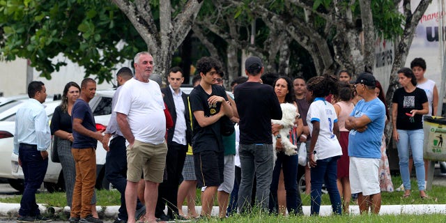 Relatives of students stand at the entrance to the Praia de Coqueiral Educational Center, one of two schools where a shooting took place, after an armed suspect opened fire, in Aracruz, Espirito Santo State, Brazil, on 25 February. November 2022.