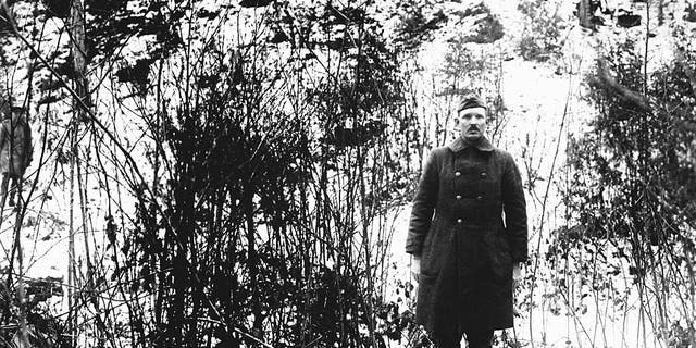Full-length portrait of Sergeant Alvin C. York (1887-1964), of the 328th Infantry Regiment, who with the aid of 17 men captured 132 German prisoners and became one of the most decorated American soldiers of World War I, near Cornay, France, February 1919. The location of the photo shows the hill upon which the raid took place. 