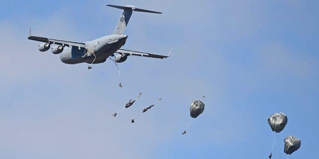 U.S. paratroopers from the 4th Infantry Brigade Combat Team (Airborne), 25th Infantry Division, descend to the drop zone after making a jump from a C-17 Globemaster as part of exercise Talisman Sabre 21 July 28, 2021, in Charters Towers, Australia. 
