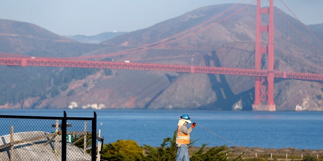 A construction worker stands on the roof of the northbound main post tunnel while work continues on the Presidio Tunnel Tops landscaping project in San Francisco on Wednesday, Nov. 1, 2017. 