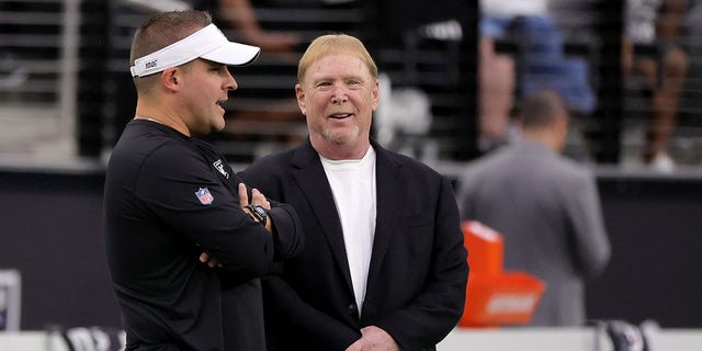 Las Vegas Raiders Head Coach Josh McDaniels (L) and Owner and Managing General Partner Mark Davis talk before a preseason game against the New England Patriots at Elegant Stadium on August 26, 2022 in Las Vegas, Nevada.  The Raiders defeated the Patriots 23–6.