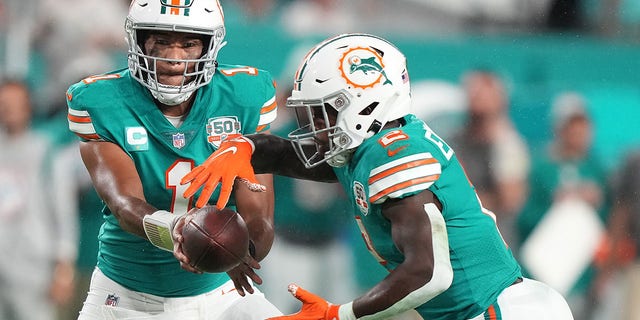 Tua Tagovailoa, #1 of the Miami Dolphins, hands the ball to Chase Edmonds, #2, during the third quarter against the Pittsburgh Steelers at Hard Rock Stadium on Oct. 23, 2022 in Miami Gardens, Florida.