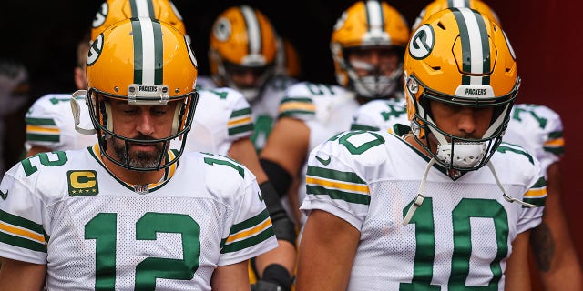 Aaron Rodgers and Jordan Love walk out on the field before a game against the Commanders