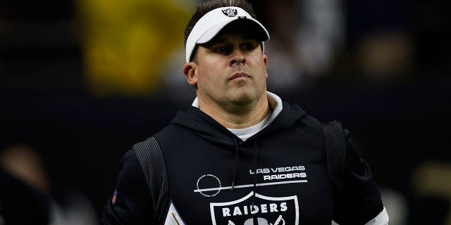 Raiders head coach Josh McDaniels walks onto the field before the Saints game.