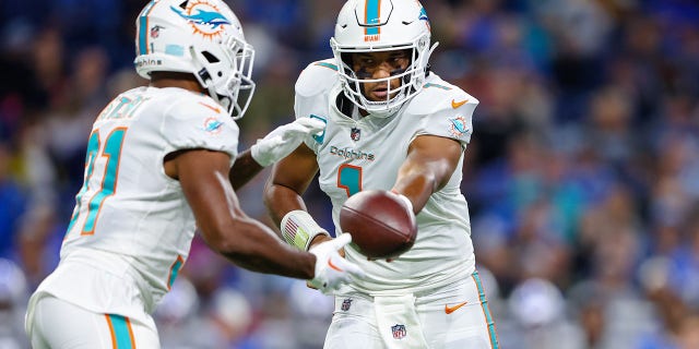 Tua Tagovailoa (1) of the Miami Dolphins hands the ball off to Raheem Mostert (31) against the Detroit Lions during the first quarter at Ford Field Oct. 30, 2022, in Detroit. 