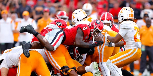 Smael Mondon Jr. (2) of the Georgia Bulldogs tackles Hendon Hooker (5) of the Tennessee Volunteers during the third quarter at Sanford Stadium Nov. 5, 2022, in Athens, Ga.