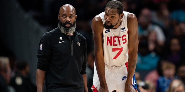 Interim head coach Jacque Vaughn of the Brooklyn Nets speaks with Kevin Durant (7) during a game at Spectrum Center on November 5, 2022 in Charlotte, NC 