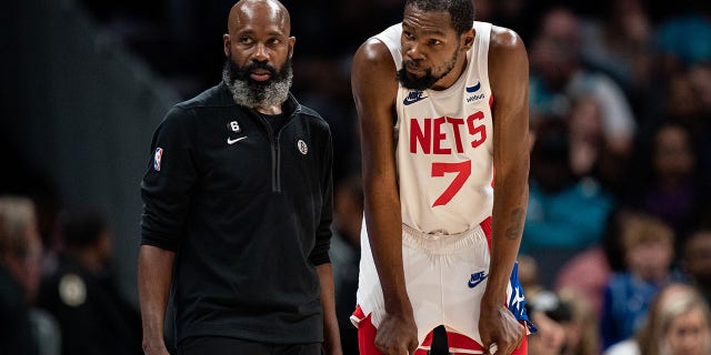 Interim head coach Jacque Vaughn of the Brooklyn Nets talks with Kevin Durant (7) during a game at Spectrum Center Nov. 5, 2022, in Charlotte, N.C.