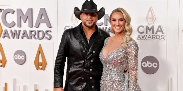 Jason Aldean and Brittany Aldean smile on the carpet of the CMA Awards