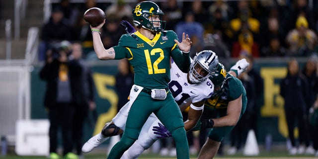 Blake Shapen (12) of the Baylor Bears throws under pressure from Felix Anudike-Uzomah (91) of the Kansas State Wildcats in the first half at McLane Stadium Nov. 12, 2022, in Waco, Texas. 