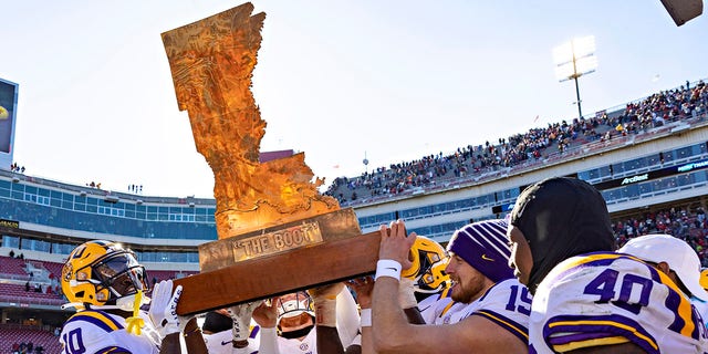 The LSU Tigers carry The Boot trophy following their win against the Razorbacks on November 12, 2022, in Fayetteville, Arkansas.