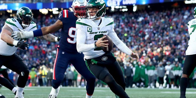 Zach Wilson, #2 of the New York Jets, battles against the New England Patriots during the third quarter at Gillette Stadium on November 20, 2022 in Foxborough, Massachusetts. 