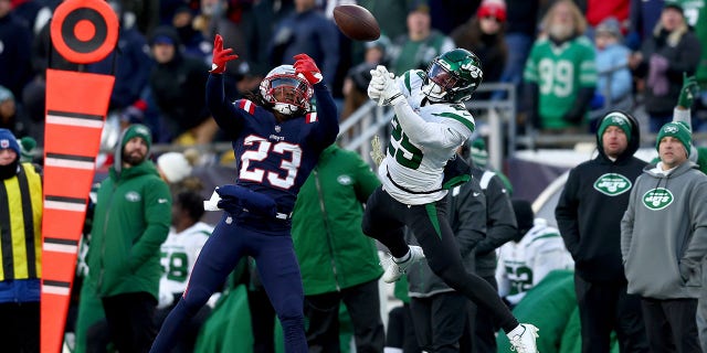 Kyle Dugger nº 23 do New England Patriots interrompe um passe destinado a Ty Johnson nº 25 do New York Jets durante o quarto período no Gillette Stadium em 20 de novembro de 2022 em Foxborough, Massachusetts.