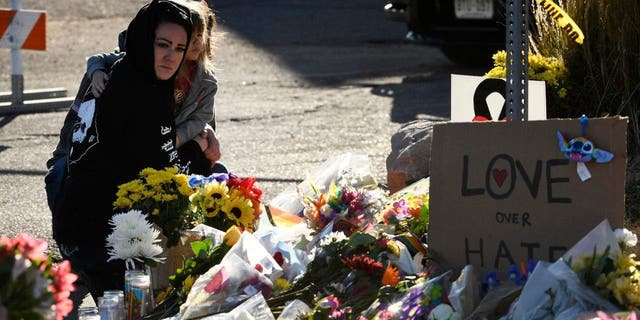 A woman and her daughter pay their respects at a makeshift memorial near Club Q on November 20, 2022 in Colorado Springs, Colorado.