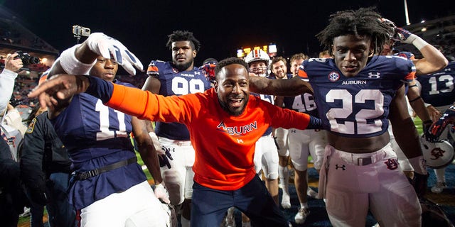 Interim head coach Carnell Williams of the Auburn Tigers celebrates with Auburn Tigers wide receiver Shedrick Jackson #11 and Auburn Tigers running back Damari Alston #22 after defeating the Western Kentucky Hilltoppers at Jordan-Hare Stadium on November 19, 2022 in Auburn, Alabama. 
