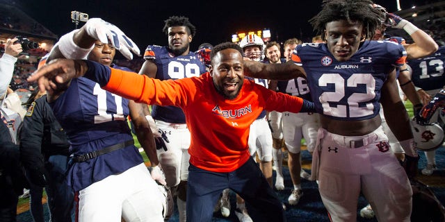Interim head coach Carnell Williams of the Auburn Tigers celebrates with wide receiver Shedrick Jackson #11 of the Auburn Tigers and running back Damari Alston #22 of the Auburn Tigers after defeating the Western Kentucky Hilltoppers at Jordan-Hare Stadium on November 19, 2022 in Auburn, Alabama.