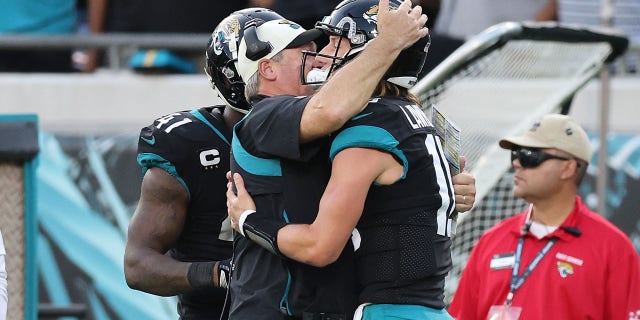 Trevor Lawrence #16 of the Jacksonville Jaguars celebrates a play with head coach Doug Pederson during the second half in the game against the Baltimore Ravens at TIAA Bank Field on November 27, 2022 in Jacksonville, Florida. 