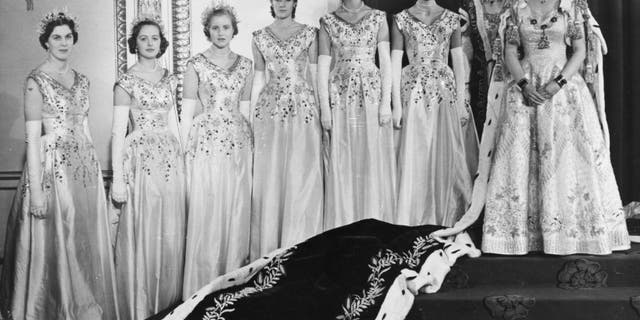 Queen Elizabeth II poses for a photograph with her Maids of Honour in the ahead of being coroneted as Queen. From left to right are Lady Moyra Hamilton, Lady Rosemary Spencer-Churchill, Lady Anne Coke (Lady Glenconner), Lady Jane Heathcote-Drummond-Willoughby, Lady Jane Vane-Tempest-Stewart, Lady Mary Baillie-Hamilton, and Mistress of the Robes, Mary Cavendish, Duchess of Devonshire. 