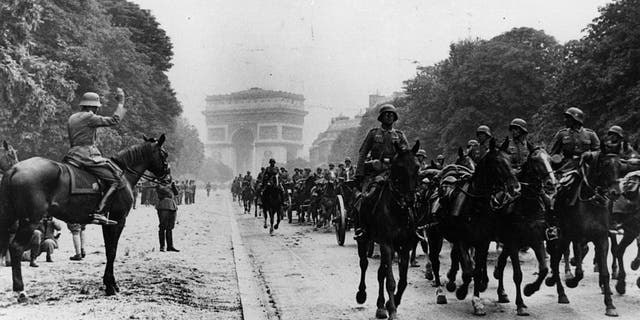 July 1940: German artillery march down the Champs Elysees from the Arc de Triomphe in Paris after taking the city.