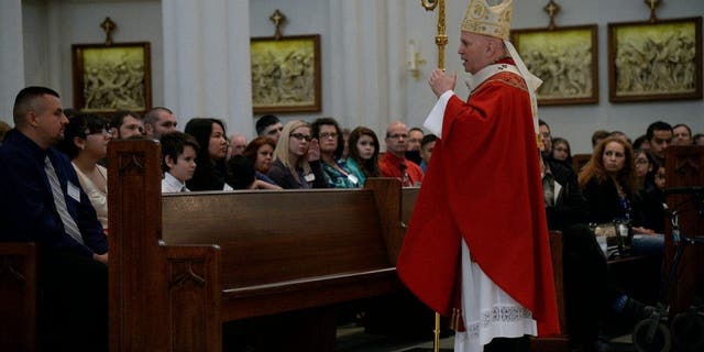 FILE - Archbishop Aquila during the Homily before anointing adults and children the Rite of Confirmation Sacrament May 24, 2015, at Cathedral Basilica of the Immaculate Conception.
