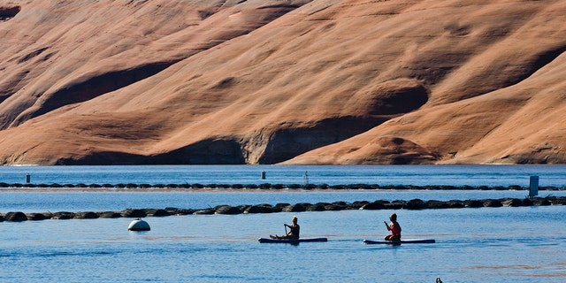 Adventurers paddle board across Lake Powell in Utah. 