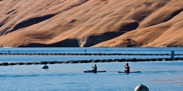 Adventurers paddle board across Lake Powell in Utah. 