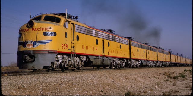 Union Pacific diesel locomotive train, Cajon Pass near Ono, California, 1964. Sprawling distances across North America and a confusing patchwork of local methods of timekeeping encouraged railroads to adopt time zones in 1883.