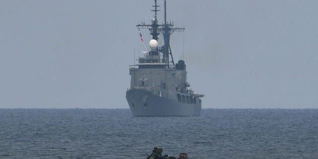 A US assault amphibious vehicle (AAV) manoeuvers past Philippine navy's frigate Ramon Alcaraz during a joint military exercisein the South China Sea 