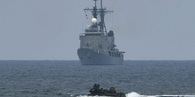 A U.S. assault amphibious vehicle maneuvers past Philippine navy's frigate Ramon Alcaraz during the amphibious landing as part of the annual Philippines and U.S. joint military exercise at the beach of Philippine navy's training camp in San Antonio, Zambales province northwest of Manila on May 9, 2018. 